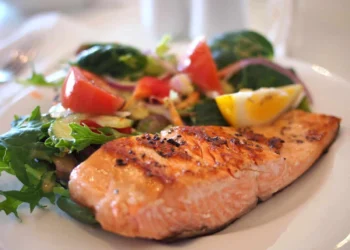 Filetto di salmone alla piastra con insalata mista di verdure fresche, esempio di pasto low-carb