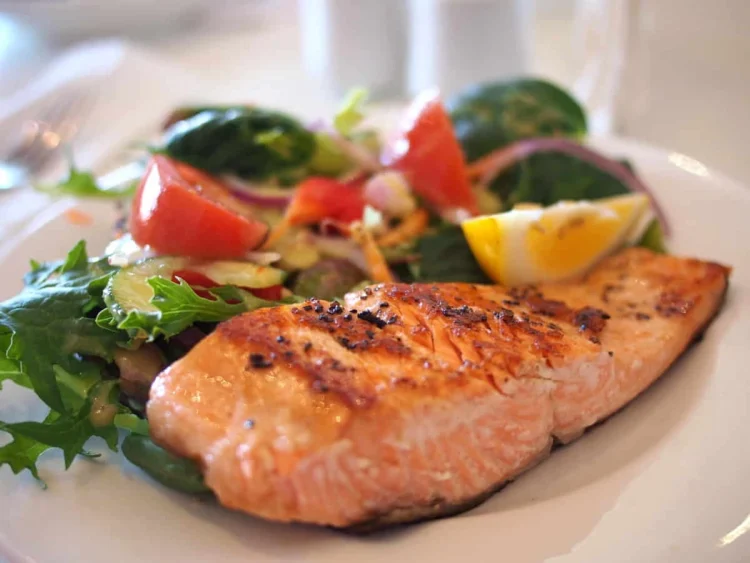 Filetto di salmone alla piastra con insalata mista di verdure fresche, esempio di pasto low-carb