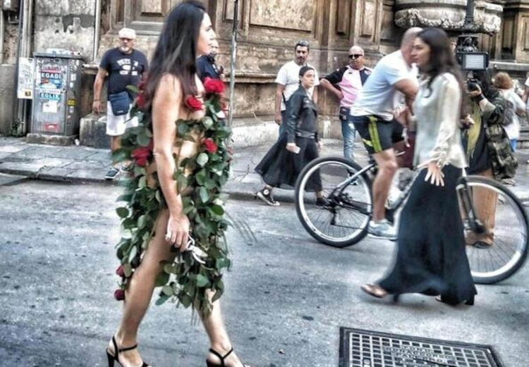 Misteriosa donna vestita di sole rose per le strade di Palermo