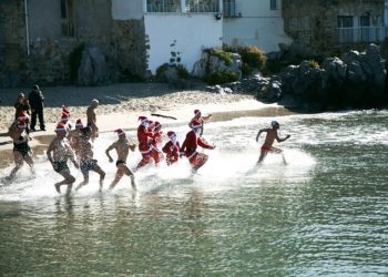 Capodanno: fanno bagno al mare vestiti da Babbo Natale