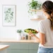 Persona di spalle in cucina luminosa con piatto sano, simbolo di controllo del peso e alimentazione equilibrata.
