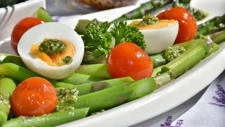 Piatto con uova sode, asparagi e pomodorini, alimenti tipici della dieta del piatto unico