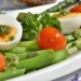 Piatto con uova sode, asparagi e pomodorini, alimenti tipici della dieta del piatto unico