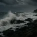 Costa siciliana durante una forte mareggiata con cielo scuro.