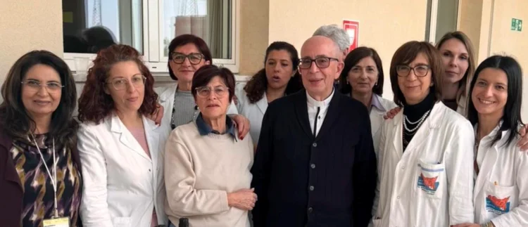 Il sacerdote Padre Giorgio Occhipinti circondato dal personale medico dell’ospedale Giovanni Paolo II di Ragusa in occasione della sua partenza.