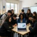 Studenti e docente scuola siciliana attorno a un laptop con interfaccia AI, progetto IA Sicilia 2025