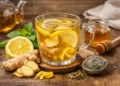 Ingredienti naturali e tazza fumante per preparare una tisana depurativa in casa con limone e zenzero.