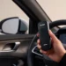 Tecnico installa alcolock su auto; dispositivo Ignition Interlock Device visibile; alcolock obbligatorio.