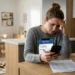 Genitore preoccupato controlla l'importo dell'Assegno Unico aprile 2026 sullo smartphone