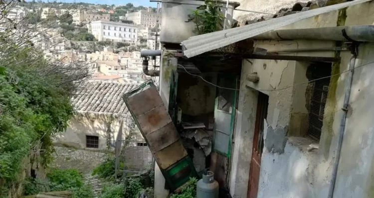 Scorcio di un vicolo storico di Modica con case in pietra antica da ristrutturare