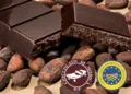 Una tavoletta di Cioccolato di Modica IGP accanto al sigillo di garanzia ministeriale durante un controllo qualità