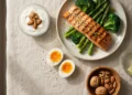 Pasto bilanciato ad alto contenuto proteico con salmone, uova, verdure e frutta secca per una dieta proteica efficace