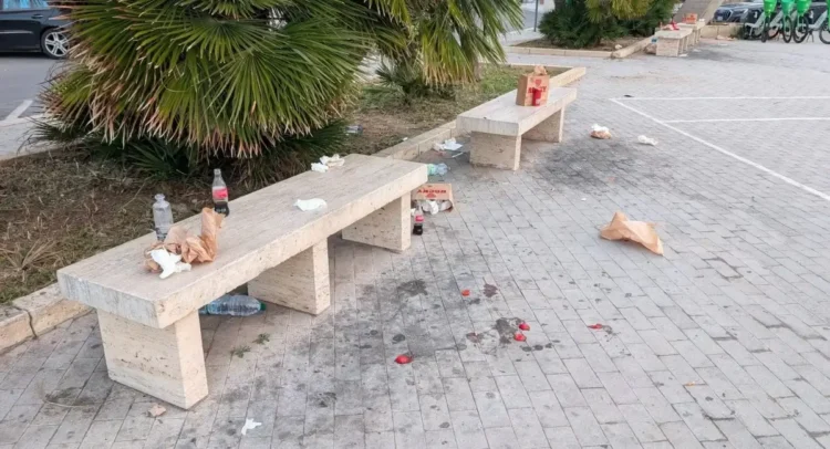 Rifiuti e bottiglie abbandonati su una panchina in pietra a Marina di Ragusa.