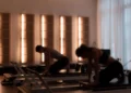 Lezione di infrared pilates in una sala moderna con pannelli infrarossi alle pareti, dei centri benessere italiani.