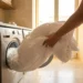 Persona che inserisce un piumone bianco in una lavatrice moderna per il lavaggio delicato