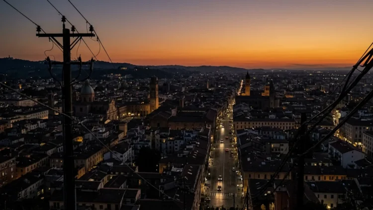 Città italiana al crepuscolo con illuminazione ridotta durante la crisi energetica