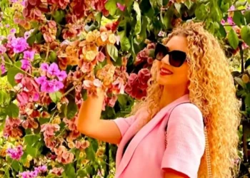 Miriam Indelicato sorridente tra fiori di bouganville rosa; la giovane studentessa di Salemi scomparsa tragicamente