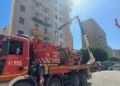 Un camion dei Vigili del Fuoco parcheggiato in via Ruggero Marturano a Palermo, con il braccio meccanico sollevato verso un edificio civile dopo l'incidente mortale sul lavoro.