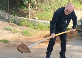 Padre Carmelo Carvello mentre ripara una buca sulla strada per Borgo Santa Rita a Caltanissetta