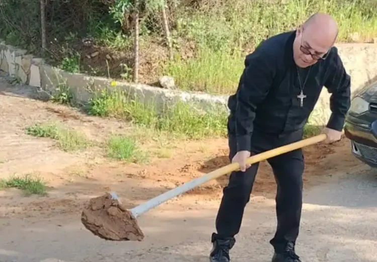 Padre Carmelo Carvello mentre ripara una buca sulla strada per Borgo Santa Rita a Caltanissetta