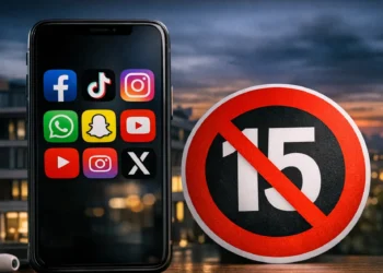 Uno smartphone con icone social e un segnale di divieto per rappresentare il limite dei social network ai minori di 15 anni.