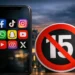 Uno smartphone con icone social e un segnale di divieto per rappresentare il limite dei social network ai minori di 15 anni.