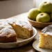 Una torta di mele soffice appena sfornata e spolverata di zucchero a velo su un tavolo di legno