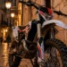 Moto da cross ferma su strada acciottolata in un centro storico siciliano di sera — immagine illustrativa generata con IA