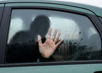 Caltanissetta donna bagagliaio auto scena urbana con auto parcheggiata