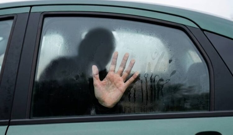 Caltanissetta donna bagagliaio auto scena urbana con auto parcheggiata