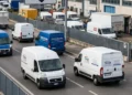 Operatori logistici con furgoni in area industriale italiana