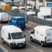 Operatori logistici con furgoni in area industriale italiana
