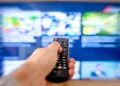 Telecomando davanti a una smart TV con guida programmi televisiva interattiva