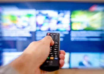 Telecomando davanti a una smart TV con guida programmi televisiva interattiva