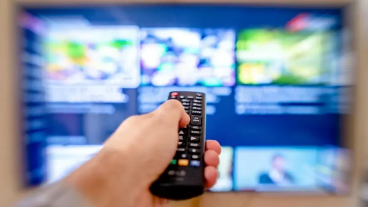 Telecomando davanti a una smart TV con guida programmi televisiva interattiva