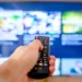 Telecomando davanti a una smart TV con guida programmi televisiva interattiva