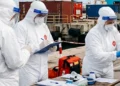 operatori sanitari in DPI su banchina portuale durante operazioni legate a focolaio hantavirus nave Hondius