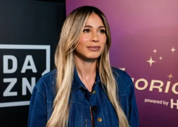 Diletta Leotta con una giacca di jeans scura durante un'intervista, con sfondo loghi DAZN e AC Milan.