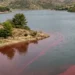 Colorazione rossa delle acque del lago Dirillo a Licodia Eubea durante la fioritura algale.