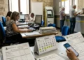 Ufficio tributi comunale con documenti fiscali e calcolatrice