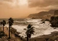 Cielo velato e giallastro sopra la costa siciliana con mare agitato per il vento.