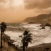 Cielo velato e giallastro sopra la costa siciliana con mare agitato per il vento.