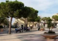 Veduta di piazza Cavour a Scoglitti con alberi, panchine e persone presenti nell'area urbana durante il giorno