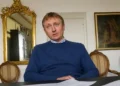 Alberto Stasi seduto a un tavolo con documenti durante un'intervista, dopo la decisione del tribunale di sorveglianza di Milano sull'affidamento in prova