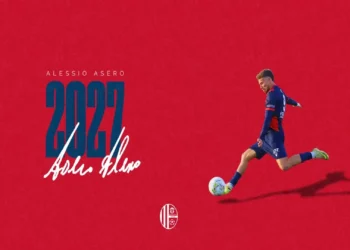 Alessio Asero in maglia rossoblù durante una fase di gioco nella grafica che annuncia la sua conferma al Modica Calcio