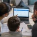 Famiglia al computer mentre consulta i documenti ISEE e i servizi INPS per l'Assegno Unico.