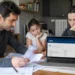 Famiglia consulta documenti ISEE e il portale INPS sul computer per l'aggiornamento dell'Assegno unico.
