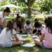 Bambini partecipano ad attività creative all'aperto insieme agli educatori durante un centro estivo in un parco.