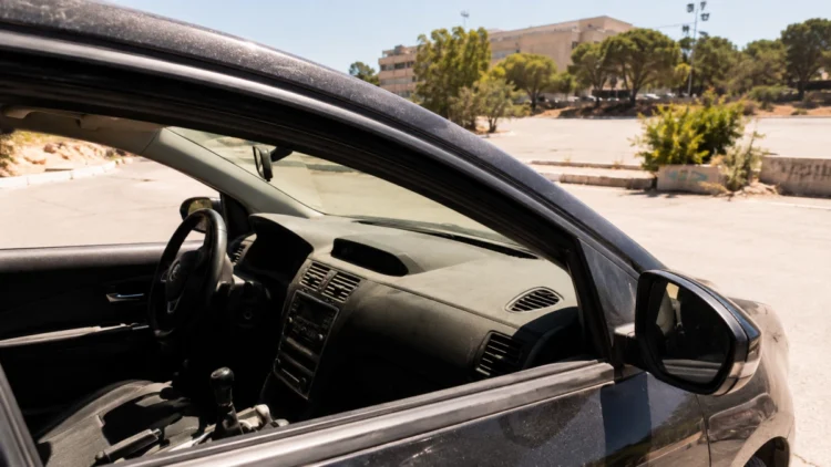 Auto parcheggiata sotto il sole estivo in un parcheggio di Marsiglia, con l'interno surriscaldato visibile attraverso il finestrino