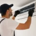 Tecnico durante la manutenzione di un climatizzatore domestico installato a parete